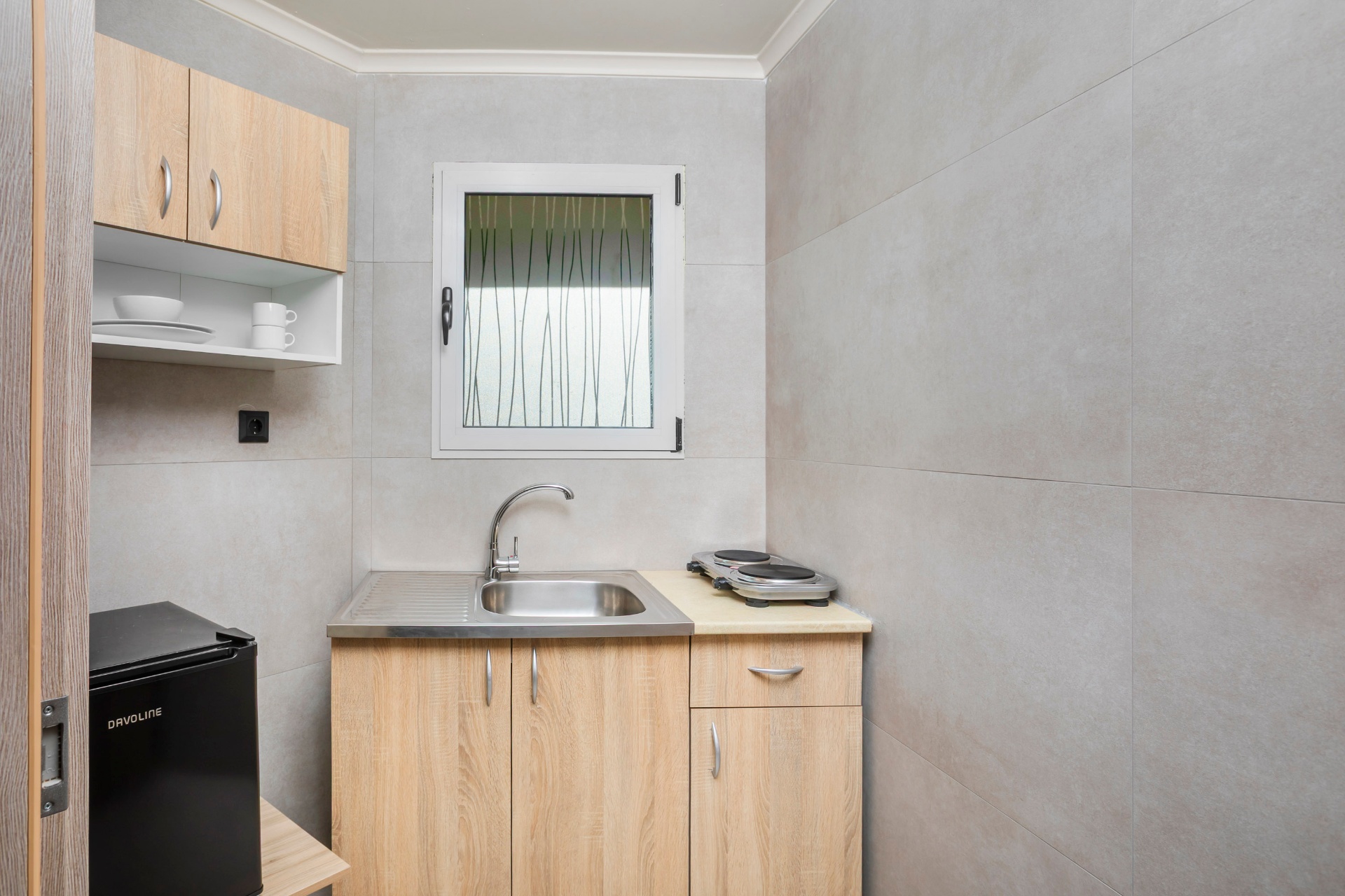 Compact kitchen corner with mini fridge and hob