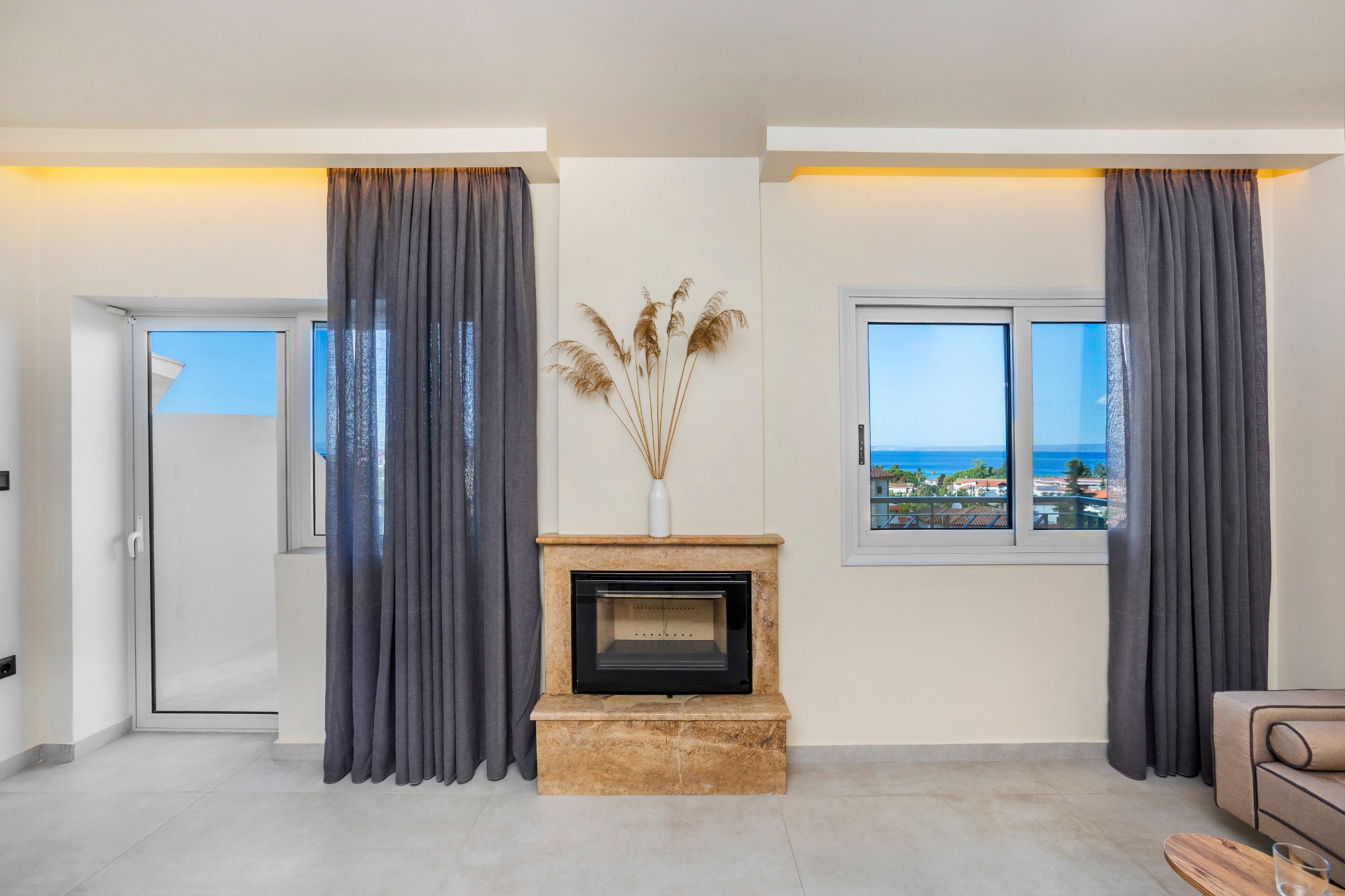 Fireplace and window framing the sea